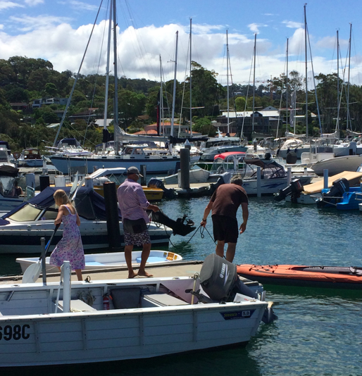 A family mooring their boat in the harbour